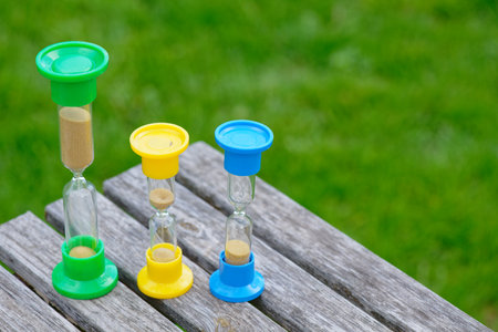 Hourglasses on the green grass natural background