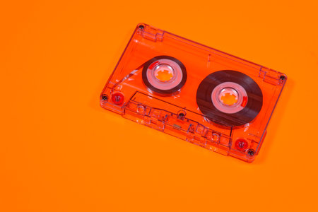 Retro audio cassettes isolated on orange background, 80's music concept. Selective focus