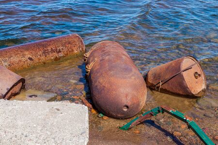Metal rusty sea buoys washed up on the shore of the Gulf of Finland.の写真素材