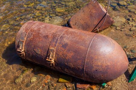 Russia. Saint-Petersburg. Metal rusty sea buoys washed up on the shore of the Gulf of Finland.の写真素材
