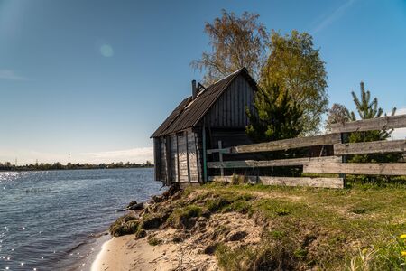 Russia. Leningrad region. A picturesque fishing house with a washed-out Foundation on the Bank of the Volkhov river at the exit to lake Ladoga.の写真素材