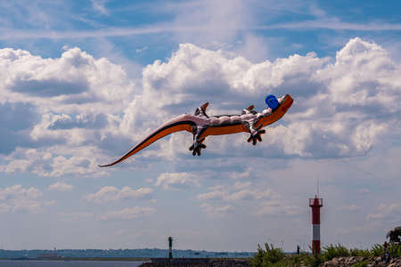 Russia. Kronstadt. June 6, 2021. An aerial flying figure of a lizard over the fairway light towers in the area of Fort Constantine during the Kronstadt Sailing Festival.のeditorial素材