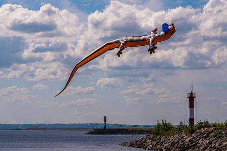 Russia. Kronstadt. June 6, 2021. An aerial flying figure of a lizard over the fairway light towers in the area of Fort Constantine during the Kronstadt Sailing Festival.のeditorial素材