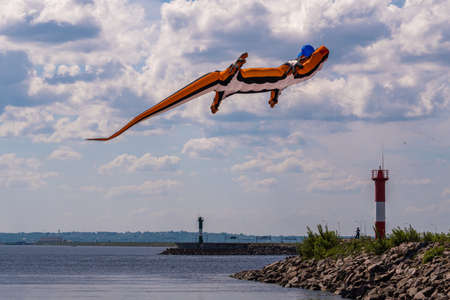 Russia. Kronstadt. June 6, 2021. An aerial flying figure of a lizard over the fairway light towers in the area of Fort Constantine during the Kronstadt Sailing Festival.のeditorial素材