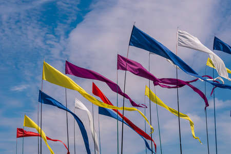 Russia. Kronstadt. June 6, 2021. Multicolored flags on flagpoles flutter in the wind against the blue sky during the Kronstadt Sail Festival at Fort Konstantin.のeditorial素材