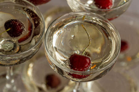 Russia. Saint-Petersburg. June 30, 2021. Red cherries in air bubbles float in champagne glasses.の写真素材