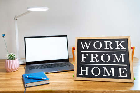 Working from home remote work inspirational social media lightbox message board next to laptop and sketchpadの写真素材