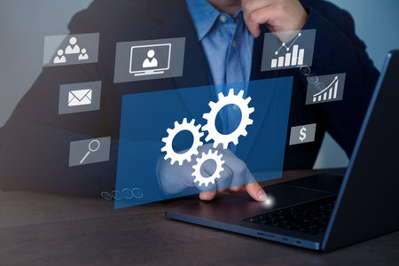 Businessman working with laptop and gear icon diagram on virtual screen.