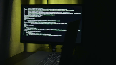 Bright screen coding, Developer working late at desk, IT startup founder examining prototype with concentration, Nighttime scene of programmer intensely reviewing product iterations in cozy workspaceの写真素材