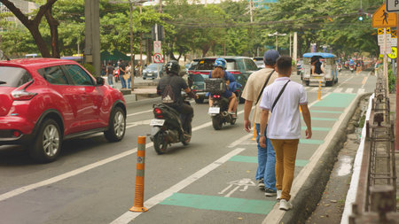 Urban men on busy street, two men strolling near lively road, casual walk through city park beside bustling street, two individuals walking leisurely along green cycle lane nearのeditorial素材