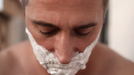 Closeup of man shaving, Man applying foam to his face carefully, Detailed shot of man grooming with...