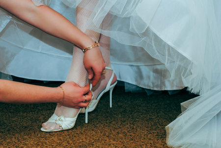 Bride girlfriend dresses white shoes before the wedding.の写真素材
