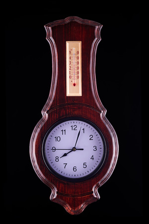 Wall clock in a wooden frame on a dark background. Fernambukの写真素材