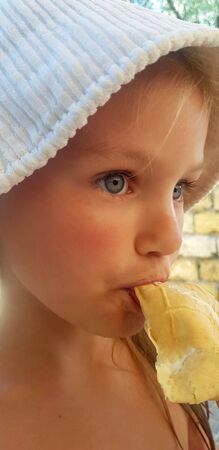 Girl in a white hat eats ice cream. Close-upの写真素材