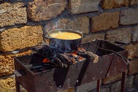 Gourmet cooking in a pot on a bonfire on a picnic.の写真素材