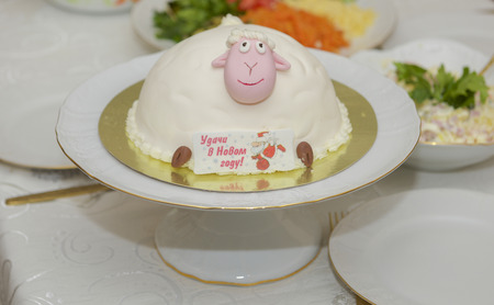 beautiful delicious cake with symbols, sheep, and Santa Claus with regards