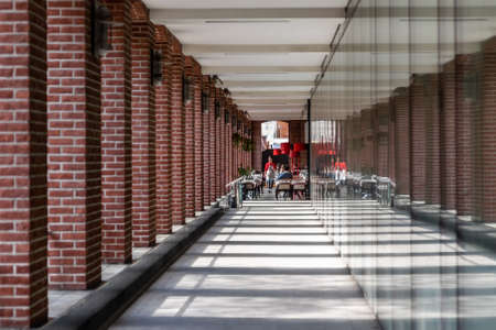 Moscow Russia - may 07 2022: View of the cafe at the end of the gallery with brick columns. Sunlight...