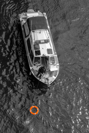 Moscow Russia - may 07 2022: Rescue boat on the river with a lifebuoy in the water. Black and white...