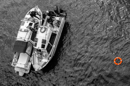 Moscow Russia - may 07 2022: Rescue boat on the river with a lifebuoy in the water. Black and white...