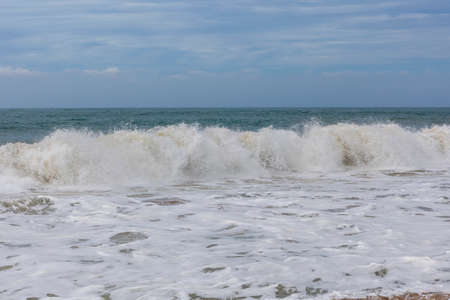 Asia. Sri Lanka. Waves beat against the seashore on the sandy beach of Ahungalla against the blue...