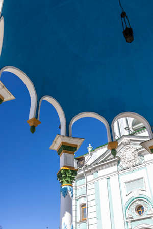 View from under the blue ceiling of the gazebo to the sky and the churchの写真素材