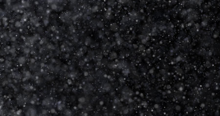 Snowfall on black background. Realistic snowflakes flying in the air.の写真素材