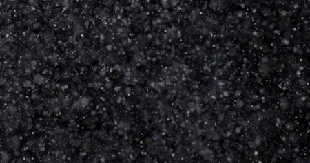 Snowfall on black background. Snowflakes flying in the air.の写真素材