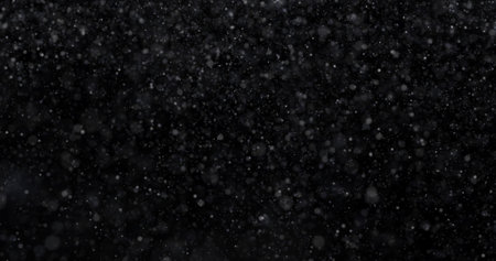 Snowfall on black background. Realistic snowflakes flying in the air.の写真素材