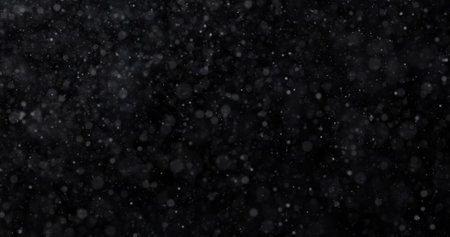 Snowfall on a black background. Snowflakes fly in the air.の写真素材