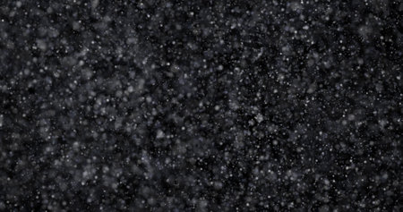Falling snow on black background. Realistic snowflakes flying in the air.の写真素材
