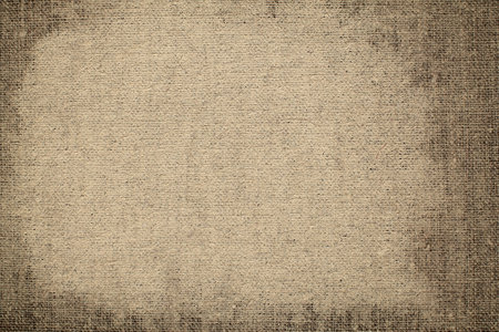 Grunge background of old textured burlap fabric with vignetteの写真素材