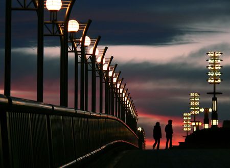  young couple walking between city lights and stormy evening sky in Tokyo Japanの写真素材