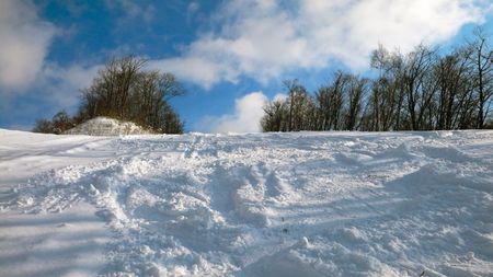 fresh snow background with mountain ski and snowboard traces on winter resort 