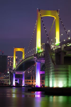 one of famous Tokyo landmarks, Tokyo Rainbow suspension bridge supports over night waters with scenic colorful illuminationの写真素材