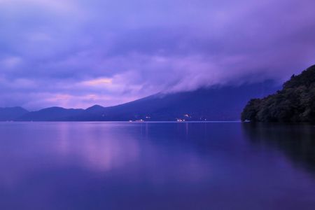  blue twilight evening of mountain lake in Japan with moving clouds and still water, Nikko, Japanの写真素材