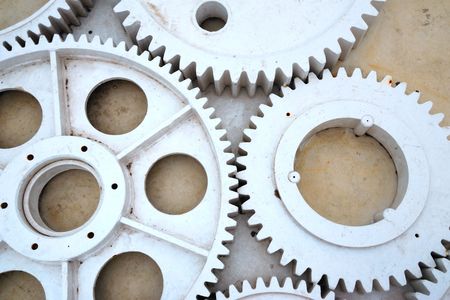 set of big industrial metallic gears on the concrete floor background
