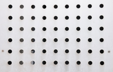white flat metallic plank with similar rows of big holesの写真素材