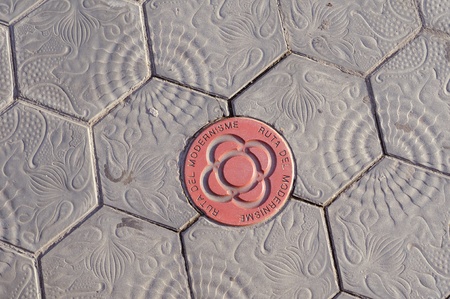 red guide mark of Barcelona Modernism Route between street pavement tiles. This is Barcelona Municipal project for discovering and recovering Modernism heritageの写真素材