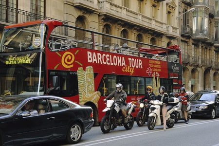 Barcelona, Spain -June 21, 2010 : big red bus with Barcelona city tour service on the Via Laietana street between cars and motorbikes.のeditorial素材