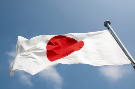 state Japanese flag on the strong wind over blue sky backgroundのeditorial素材