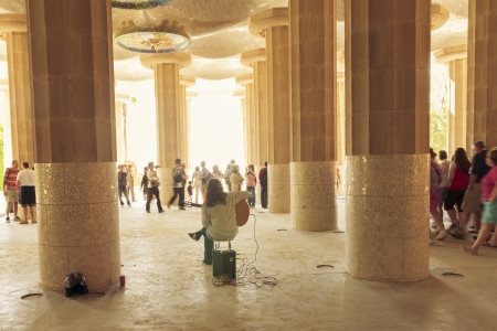 Barcelona, Spain -June 19  :  street musician play on guitar under big columns with many visitors walking around in Sala Hipostila at Park Guell  in Barcelona.のeditorial素材