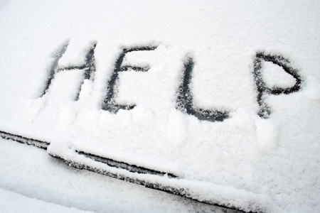 Help word written on front car window covered by heavy wet snowの写真素材