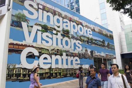 Singapore - January 12,  2013: Pedestrians walk along Singapore Visitors Centre wall on famous Orchard road in Singapore City.のeditorial素材