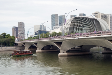 Singapore, Singapore - January 10,  2013: People walks by well arranged Esplanade drive bridge in Singapore downtown. There are futuristic domes of famous Esplanade Theatres on background.のeditorial素材