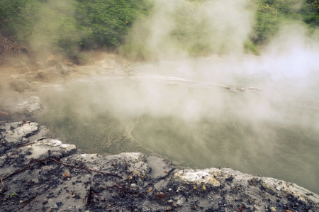 natural hot basin with steam over it in volcanic area of Hokkaido islandの写真素材