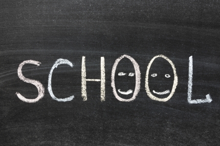 school word with smiling faces handwritten on blackboardの写真素材