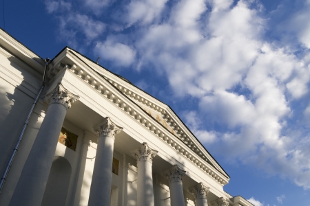 fragment of classic building facade with blue cloudy skyの写真素材