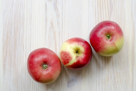 three red apples on the white wooden tableの写真素材