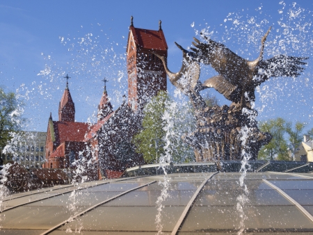 fountain splashes by sunny day at the Nezalezhnascy Square  in Minsk city with famous Red Church behindの写真素材