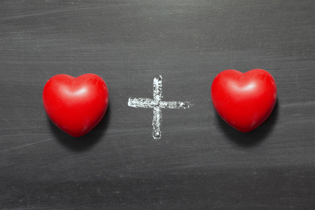 heart plus heart chalk drawing on blackboardの写真素材